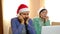 Loving multiracial couple, man and woman in Santa hats are smiling and hugging, talking by online video call