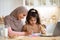 Loving Muslim Mom In Hijab Drawing With Her Little Daughter In Kitchen