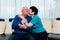 Loving older wife kissing smiling husband on cheek, expressing love and care, aged senior couple enjoying tender moment.