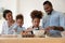 Loving parents teach little children baking in kitchen