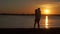 Loving senior couple enjoying a romantic sunset evening dancing together on the beach filmed