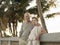 Loving Senior Couple Leaning Against Wall On Beach