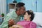 loving supportive husband comforts his wife during her hospital stay by kissing her forehead - concept of caring partner