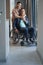 Loving woman hugging husband on wheelchair indoors