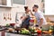 Loving young Asian couple cooking in kitchen making healthy food