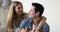 Loving young couple cuddling seated on sofa at home