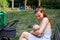 Loving young mother breastfeeding, beautiful mom nursing her little newborn child in public place, baby feeding time outside