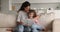 Loving young mother reading book to little preschool daughter