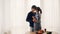 Loving young people husband and wife are dancing in kitchen and kissing laughing and smiling enjoying romantic moment at