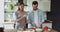 Loving young woman feeding smiling husband, preparing food together.