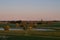 A low aerial view of the southern Sweden landscape with trees and a small lake in the rural area called SkÃ¥ne