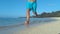 LOW ANGLE: Active young man on holiday jogs in the wet sand along sandy beach.