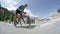 LOW ANGLE: Active young man on road bicycle charging uphill in a pro bike race.