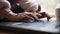 Low angle closeup view of female hands typing on laptop computer keyboard