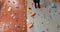 Low angle of coach assisting woman in bouldering 4k