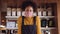 Low Angle, Confident Female African coffee shop owner wearing face mask walking up and leaning on counter