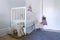 Low angle corner view of pretty pale baby room with stuffed teddy bear toys