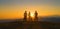 LOW ANGLE: Golden sun rays illuminate cross country bikers on the mountaintop.