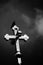 Low angle greyscale shot of a cross with a black crow on it.