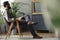 Low angle of hipster sitting on wooden armchair in grey vintage