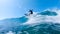 LOW ANGLE, LENS FLARE: Cheerful surfer riding big ocean wave in sunny nature.