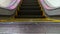 Low angle looped perspective view of modern escalator stairs. Automated elevator mechanism. Yellow line on stairway