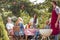 Low angle of man grilling food and happy friends during birthday party in the garden