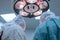 low angle, pediatric surgeons perform surgery in a sterile operating room. The view from the back. Illuminates the operating field