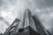 A low angle photo of a modern glassy building, cloudy day