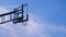 Low angle and rear side view of outdoor transparent basketball backboard against white cloud and blue sky background