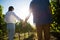 Low angle rear view of couple holding hands at vineyard