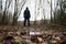 A low angle, shallow depth of field of a spooky blurred hooded figure. Standing on the edge of woodland