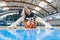 Low angle shot of a blond cheerleader sitting on the floor with a basketball between her legs. Sport concept.