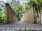 Low-angle shot of a bridge path leading to the Kitekite Falls waterfall near Auckland, New Zealand