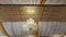 Low angle shot of a chandelier in the ceiling with white and yellow textiles