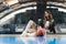 Low-angle shot of a cheerleader sitting on the floor with her leg bent and her hand on a basketball. Sport concept.