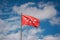 Low angle shot of the Flag of the Community of Madrid on a pipe under a blue cloudy sky