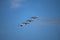 Low angle shot of four military aircraft with smoke trails in theblue clear sky