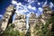 Low angle shot of four rock formations surrounded by plants under the beautiful cloudy sky