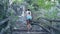 Low angle shot girl in shorts goes up stone steps on hill