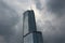 Low angle shot of a gray skyscraper under a cloudy sky