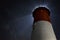 Low angle shot of an illuminated lighthouse under the sky full of stars