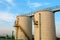 Low-angle shot of ladder and tanks refinery.