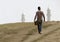 Low angle shot of a male on the hills with Hazrat Sultan Mosque in the background in Kazakhstan