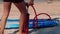 Low-angle shot man inflates paddle board with hand pump