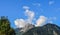 Low angle shot of the mesmerizing mountain peak against the blue sky with clouds