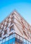 Low angle shot of a modern office building with balconies under a blue sky