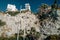 Low angle shot of modern white buildings on a cliff and green palm trees