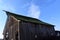 Low angle shot of an old barn with a mossy roof in the farm