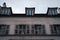 Low angle shot of an old building with three dormer window under sunset sky in Paris, France